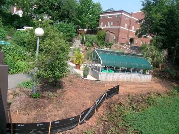 August 2008: Contractors survey and clear area around LAEG greenhouse and pedestrian footbridge for placement of wall to enclose the Thomas Street side of the garden.